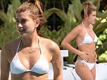 EXCLUSIVE TO INF. PREMIUM RATES APPLY.\nJune 12, 2015: Model Hailey Baldwin, who was rumored to be dating Justin Bieber, is seen wearing a white string bikini while hanging out with a mystery man poolside in Miami Beach, Florida. The model was later seen on a coffee run at Starbucks wearing a striped mini-dress. \nMandatory Credit: INFphoto.com Ref: infusmi-11/13
