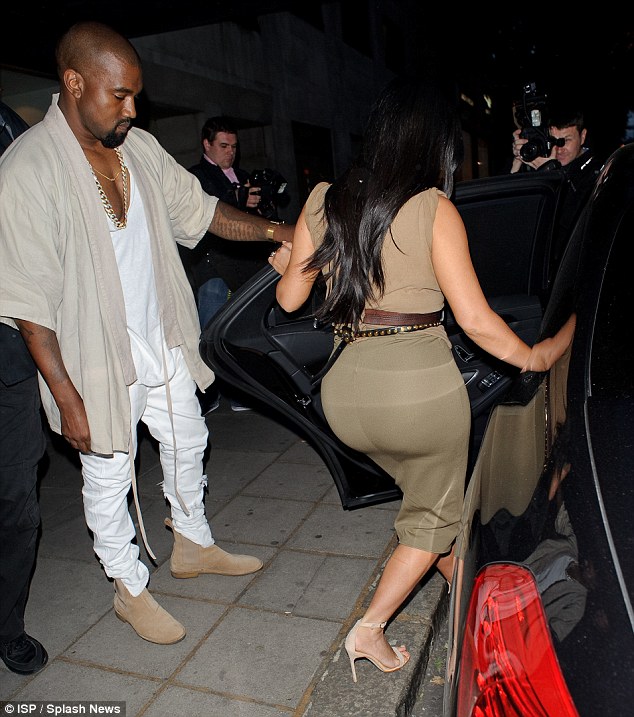 Can't resist: Kanye took a sneaky peek at his wife's derriere as he helped her into the car 