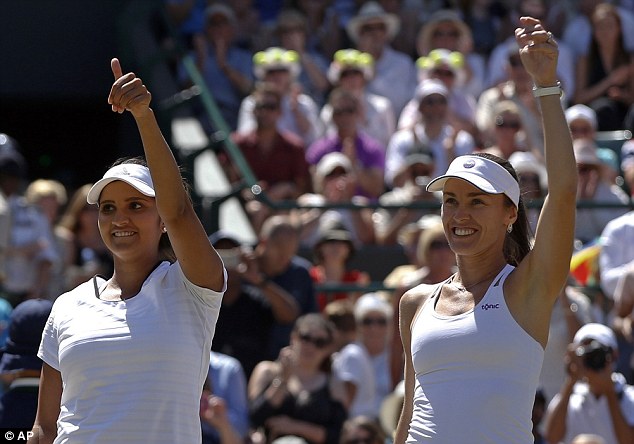 Martina Hingis (right) and Sania Mirza (left) raise their hands after reaching the Wimbledon doubles final
