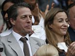 British actor Hugh Grant (L) sits on Centre Court to watch the men's singles final match between Serbia's Novak Djokovic and Switzerland's Roger Federer on day thirteen of the 2015 Wimbledon Championships at The All England Tennis Club in Wimbledon, southwest London, on July 12, 2015.  RESTRICTED TO EDITORIAL USE  --  AFP PHOTO / ADRIAN DENNISADRIAN DENNIS/AFP/Getty Images