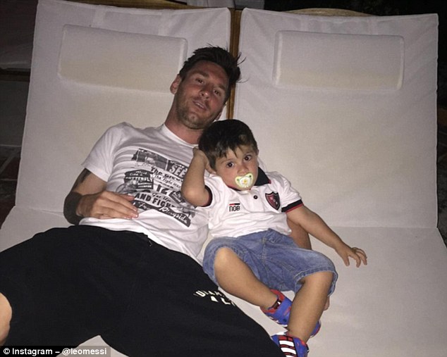 Lionel Messi (left) has kitted his son out in a Newell's Old Boys polo shirt for a holiday snap in the Caribbean