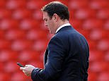 Cardiff City's Scottish manager Malky Mackay looks at his mobile phone before the start of the English Premier League football match between Liverpool and Cardiff City at Anfield stadium in Liverpool, northwest England, on December 21, 2013.  AFP PHOTO / PAUL ELLIS  RESTRICTED TO EDITORIAL USE. No use with unauthorized audio, video, data, fixture lists, club/league logos or live services. Online in-match use limited to 45 images, no video emulation. No use in betting, games or single club/league/player publications.        (Photo credit should read PAUL ELLIS/AFP/Getty Images)