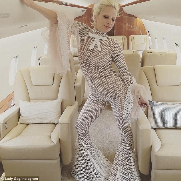 Interesting choice of travel attire: Lady Gaga dared to go almost bare in a white jumpsuit perforated with holes that clearly revealed her boobs  as she flew on a private jet, which she posted on Instagram on Monday