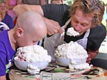 Ethan Gehman, 7, of Littleton, Colo., left, who is visiting Gives Kids the World, squares off against actor Kevin Bacon to see who can eat the most ice cream in six seconds in Kissimmee, Fla., Monday, July 27, 2015. The loser, who was Bacon, donated $6.00 to Give Kids The World, a 74-acre resort where children with serious illnesses and their families are treated to dream vacations. Bacon is founder of SixDegrees.org, which encourages celebrities to use their fame to benefit worthy causes. Bacon is visiting the Village to highlight the fact that everyone is six degrees or less away from knowing a child with a life-threatening illness. (Red Huber/Orlando Sentinel via AP)