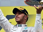 Mercedes AMG Petronas F1 Team's British driver Lewis Hamilton celebrates winning with the trophy  on the podium at the Spa-Francorchamps circuit in Spa on August 23, 2015, after the Belgian Formula One Grand Prix. AFP PHOTO / ANDREJ ISAKOVICANDREJ ISAKOVIC/AFP/Getty Images