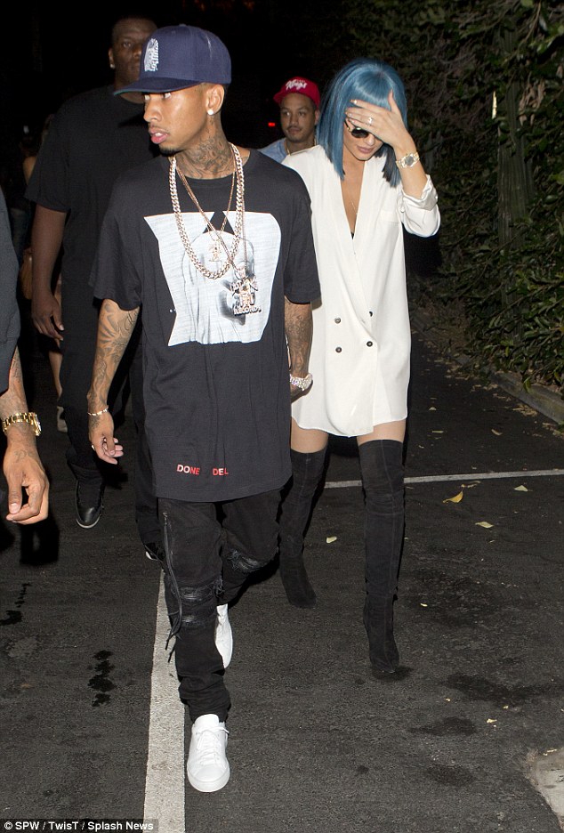 Signature style: Her boyfriend Tyga looked typically casual in an over-sized T-shirt and ripped jeans as they enjoyed a night out together