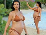 **STRICTLY NO WEB UNTIL 4PM GMT**
**PREMIUM EXCLUSIVE RATES APPLY** Pregnant and bikini-clad Kim Kardashian takes a walk on the beach with mom Kris and friend Joyce in St Barts