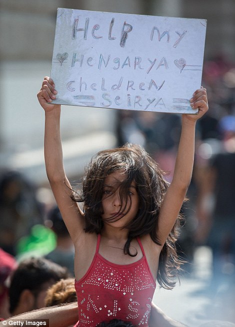 BUDAPEST, HUNGARY - SEPTEMBER 02:  A young Syrian girl holds up a sign as migrants protest outside Keleti station which remains closed to them in central Budapest on September 2, 2015 in Budapest, Hungary. The station was closed yesterday in what was said to be an attempt by the Hungarian government to uphold EU law and restore order after recent choatic scenes at the station as migrants attempted to board trains to other parts of Europe. According to the Hungarian authorities a record number of migrants from many parts of the Middle East, Africa and Asia are crossing the border from Serbia. Since the beginning of 2015 the number of migrants using the so-called Balkans route has exploded with migrants arriving in Greece from Turkey and then travelling on through Macedonia and Serbia before entering the EU via Hungary. The massive increase, said to be the largest migration of people since World War II, led Hungarian Prime Minister Victor Orban to order Hungary's army to build a steel an