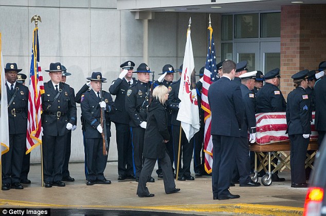 Officers salute as the flag-draped casket carrying Gliniewicz arrives for the funeral in Antioch, Illinois, on Monday