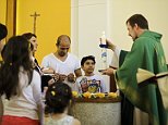 Pastor Gottfried Martens lights a candle during a service to baptize people from Iran, in the Trinity Church in Berlin, Aug. 30, 2015. Third right is Iranian asylum-seeker Mohammed Ali Zanoobi. He is one of hundreds of mostly Iranian and Afghan asylum seekers who have converted to Christianity at the evangelical Trinity Church in the leafy Berlin neighborhood. Most say true belief prompted their embrace of Christianity, but thereís no overlooking the fact that the decision will also greatly boost their chances of winning asylum by allowing them to claim they would face persecution if sent home. (AP Photo/Markus Schreiber)