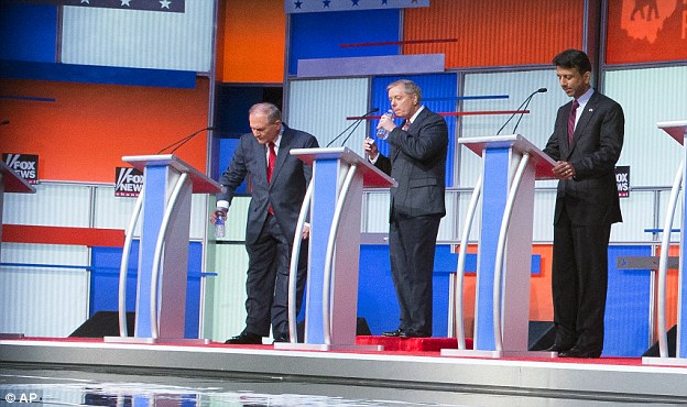 Booster: Lindsey Graham, center, was given a large, red box to make him look taller for his debate with Republican opponents on Thursday night. He is pictured between Jim Gilmore and Bobby Jindal