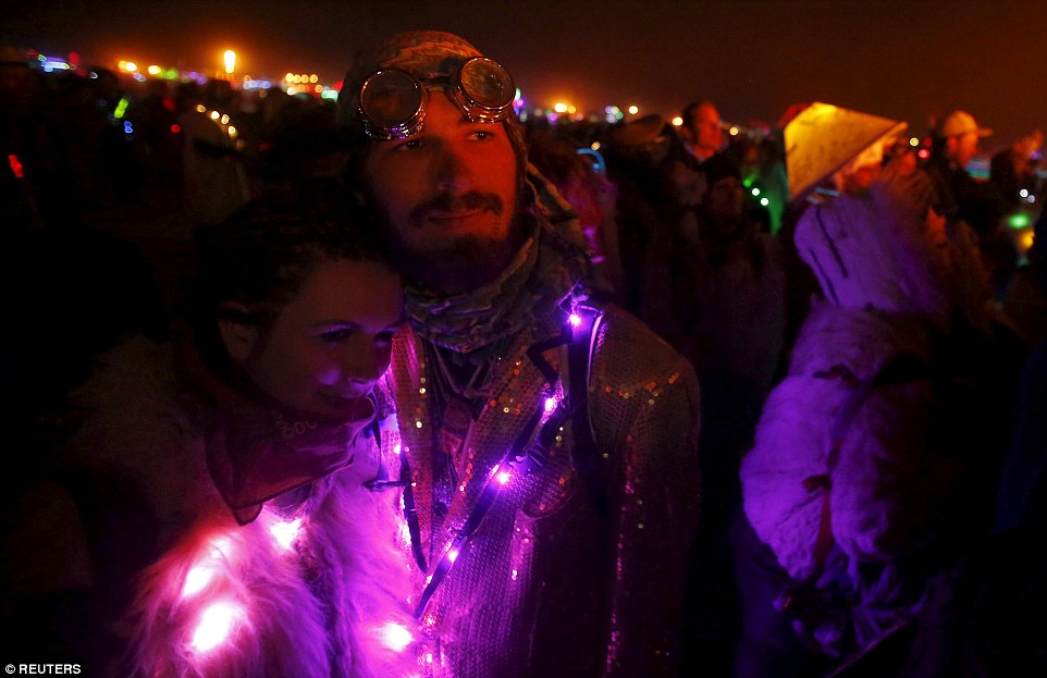 Hannah Neil (left) and Austin Bennett (right) embrace as they watch the Man burn on Saturday night as the festival came to a close