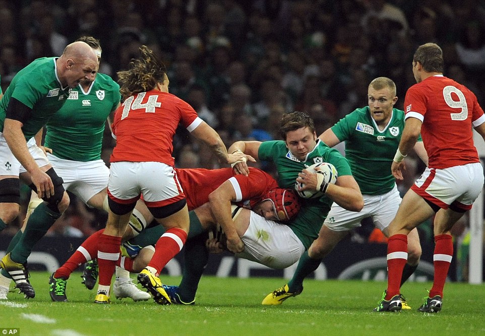 Henderson holds onto the ball after being hit with a strong challenge during the Rugby World Cup Pool D clash 
