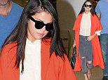 PLEASE CALL INF NYC DIRECTLY FOR USAGE at 212-582-0066 OR 917-4966. EXCLUSIVE TO INF.\nSeptember 19, 2015: Selena Gomez travels in style wearing a red trench coat, ripped skinny jeans, and stiletto heels as she arrives to Miami International Airport to catch a flight in Miami, FL.\nMandatory Credit: INFphoto.com Ref: infusmi-11/13