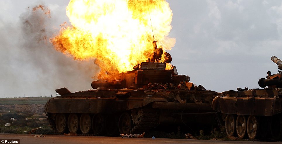 Blaze: A fire in a tank, belonging to Gaddafi's forces, roars after it is hit by an air strike