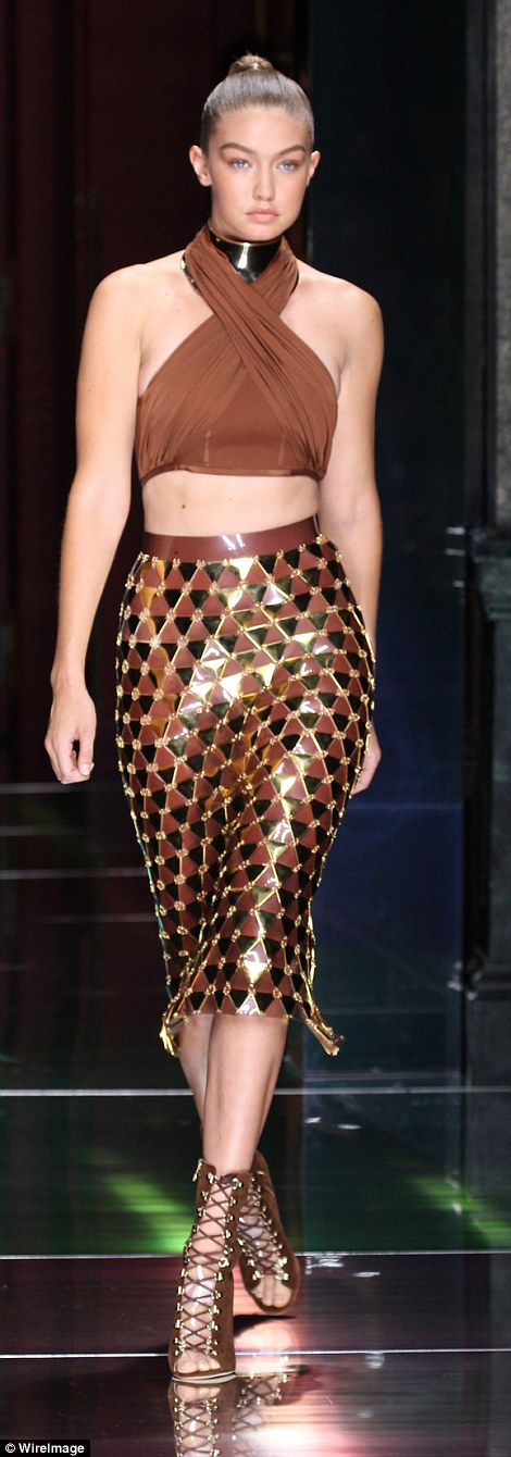 Golden girl: Gigi Hadid wore a chainlink skirt with a very sexy brown halter neck crop top