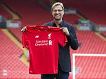 Liverpool's new manager Juergen Klopp poses for pictures in front of the Spion Kop stand after being appointed the club's new manager on a three-year deal, Liverpool, England, Friday, Oct. 9, 2015. The 48-year-old German has been out of work since May, when he ended a seven-year spell at Borussia Dortmund to take a sabbatical. (AP Photo/Jon Super)