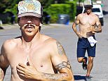 UK CLIENTS MUST CREDIT: AKM-GSI ONLY\nEXCLUSIVE: Malibu, CA - Anthony Kiedis takes a shirtless jog in Malibu. The Red Hot Chili Peppers vocalist, put his famous tattoos on display as he ran through his neighbor hood on a sunny day at the coast working up a healthy sweat.