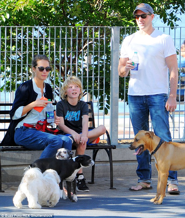 Perfect day: Christy looked very content as she sat on a bench with her son, while her producer/director husband kept an eye on the furry members of their family