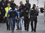 Hooded police officers walk in a street of  Saint-Denis, near Paris, Wednesday, Nov. 18, 2015.  A woman wearing an explosive suicide vest blew herself up Wednesday as heavily armed police tried to storm a suburban Paris apartment where the suspected mastermind of last week's attacks was believed to be holed up, police said. (AP Photo/Peter Dejong)