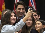 Canadian Prime Minister Justin Trudeau has his photo taken with students from a local school following an information session on climate change during a First Ministers meeting at the Museum of Nature on Monday, Nov. 23, 2015 in Ottawa. (Adrian Wyld/The Canadian Press via AP) MANDATORY CREDIT