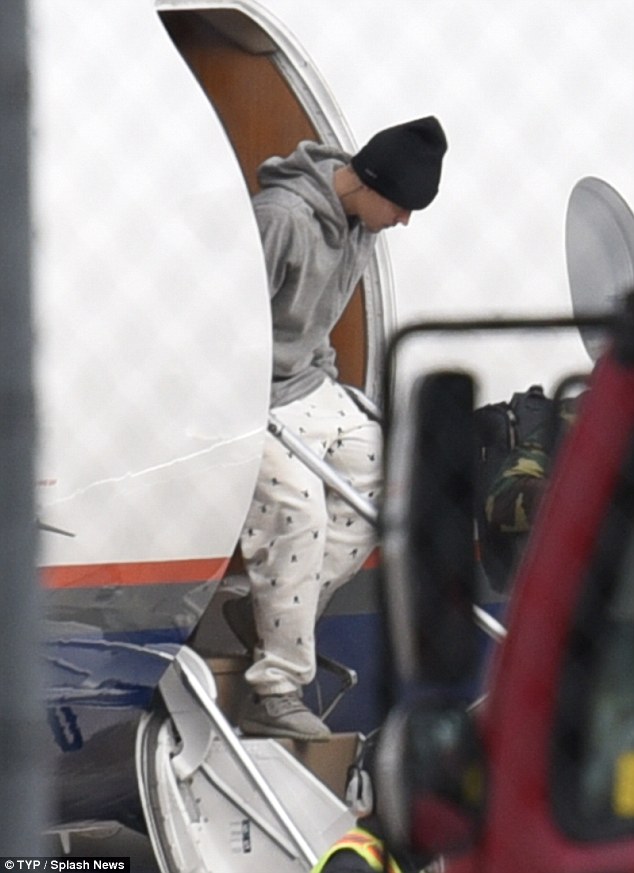 At least he kept his shirt on: Justin Bieber was all wrapped up as he got off his plane in Toronto on Monday just hours after his thrilling topless performance in London