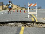 ca. June 26-30, 1992, Landers, California, USA --- A large crack runs across a road. The offset yellow line on either side shows how far the highway was shifted by the large earthquake. | Location: Near Landers, California, USA. --- Image by © Roger Ressmeyer/CORBIS