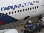 In this May 27, 2015 photo, a member of ground staff loads luggage to a Malaysia Airlines Boeing 737-800 at the Kuala Lumpur International Airport in Sepang, Malaysia.  Malaysia Airlines Tuesday Jan. 5, 2016 barred passengers from checking in baggage on flights to Paris and Amsterdam for two days due to "unseasonably strong headwinds" on a longer flight path it is taking. The move affecting Tuesday and Wednesday flights has baffled passengers, who slammed the airline on social media. (AP Photo/Vincent Thian)
