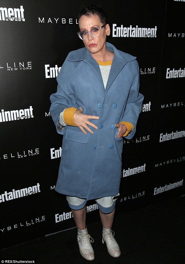 Eccentric: Lori Petty wore a double breasted blue coat over a grey dress and worn out white leather shoes