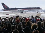 Supporters of U.S. Republican presidential candidate Donald Trump watch his plane arrive before a campaign rally in Dubuque, Iowa January 30, 2016. REUTERS/Rick Wilking