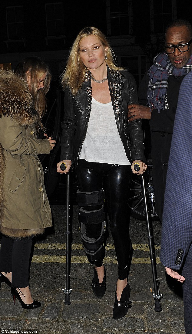 Hobbling about: Kate, pictured at a party in London last month, is still on crutches after injuring her knee during a skiing trip to Verbier, Switzerland 