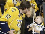 Nashville Predators forward Mike Fisher kisses his wife, singer Carrie Underwood, as Fisher is honored for his 1,000th NHL hockey game before the first period of a game against the Los Angeles Kings Monday, March 21, 2016, in Nashville, Tenn. Underwood holds their son, Isaiah. (AP Photo/Mark Humphrey)
