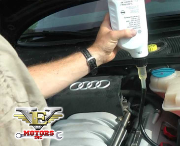 photo of mechanic giving an oil change on an audi with VE Motors logo and phone number