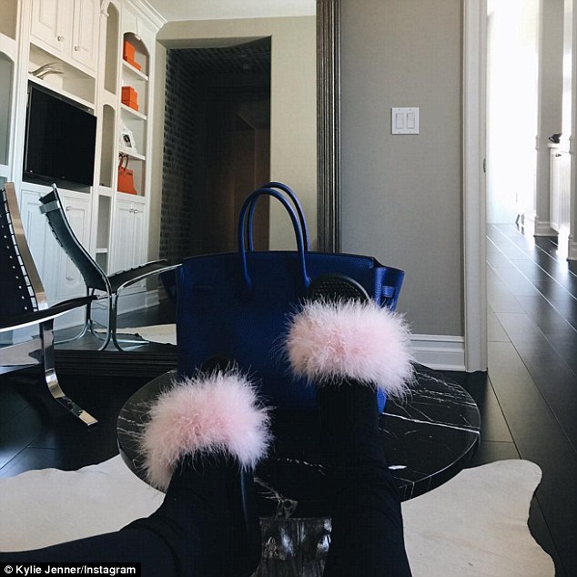 Quick rest before hitting the road: She also shared a close up of her slippers and handbag while taking a seat, captioning it simply: 'Shmoood'