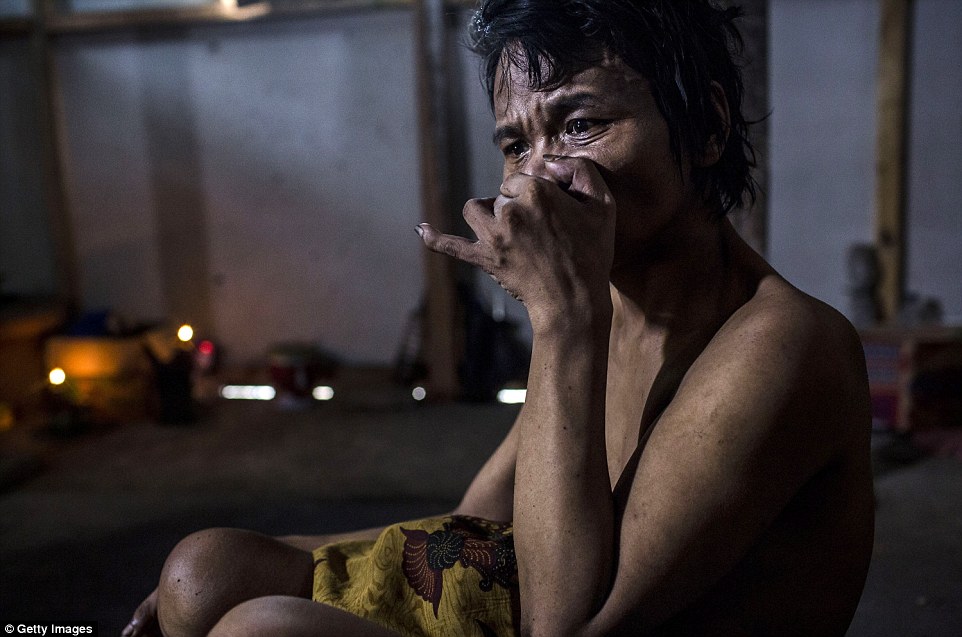 Saimun, 45, lies on the ground inside his house, where his legs have been chained for 20 years by his parents because he suffers from mental illness