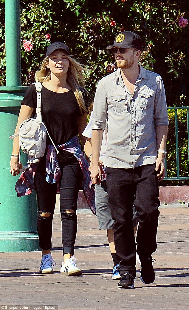 The couple that dresses together! The pair were in sync in matching jeans as they strolled around the amusement park