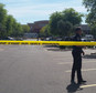 Chandler police spokesman Seth Tyler stands behind crime tape at the scene of a police involved shooting at a Walmart store on Saturday, April 23, 2016 in Chandler, Ariz. Authorities in a Phoenix suburb say two officers have been shot and a suspect is dead. Tyler says both officers are hospitalized in stable condition. (AP Photo/Terry Tang)