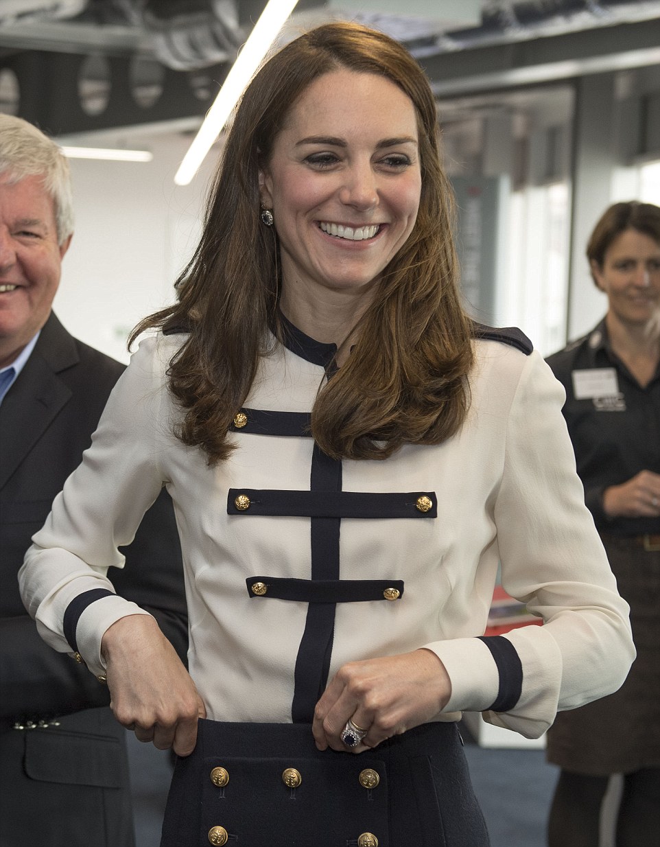 The Duchess adjusts her Alexander McQueen skirt with gold nautical buttons 