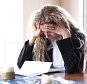 A stock photo of a woman worried about bills and debt.


CNB0FM
