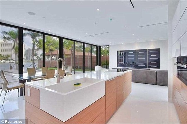 The kitchen's oversized windows look out onto the pool and the waterfront