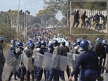 Armed Zimbabwean police clash with rioters in Harare, Monday, July, 4, 2016. Police in Zimbabwe's capital fired tear gas and water cannons in an attempt to quell rioting by taxi and mini bus drivers protesting what they describe as police harassment.  The violence came amid a surge in protests in recent weeks because of economic hardships and alleged mismanagement by the government of President Robert Mugabe. (AP Photo/Tsvangirayi Mukwazhi)