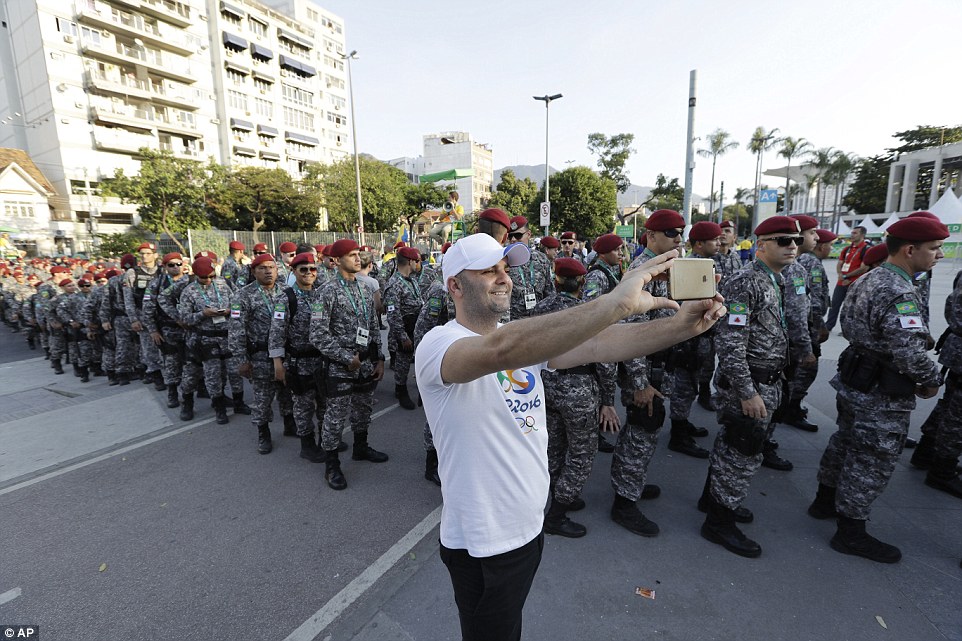I'm with them: A sports fan sneaked a selfie as columns of Brazilian soldiers stood guard outside the Maracana Stadium