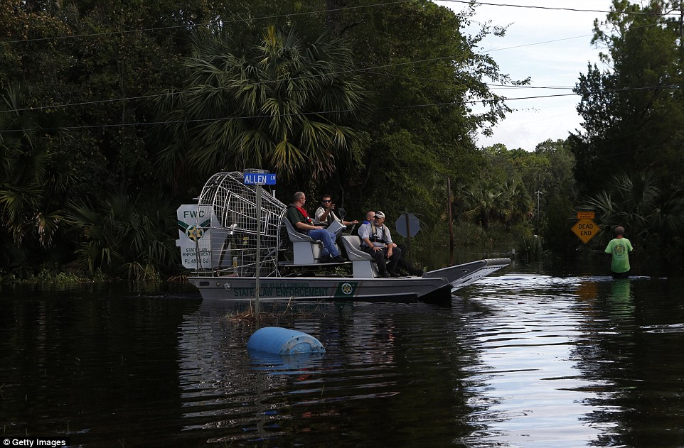 Law enforcement officers use an airboat to survey damage around homes from high winds and storm surge associated with Hurricane Hermine