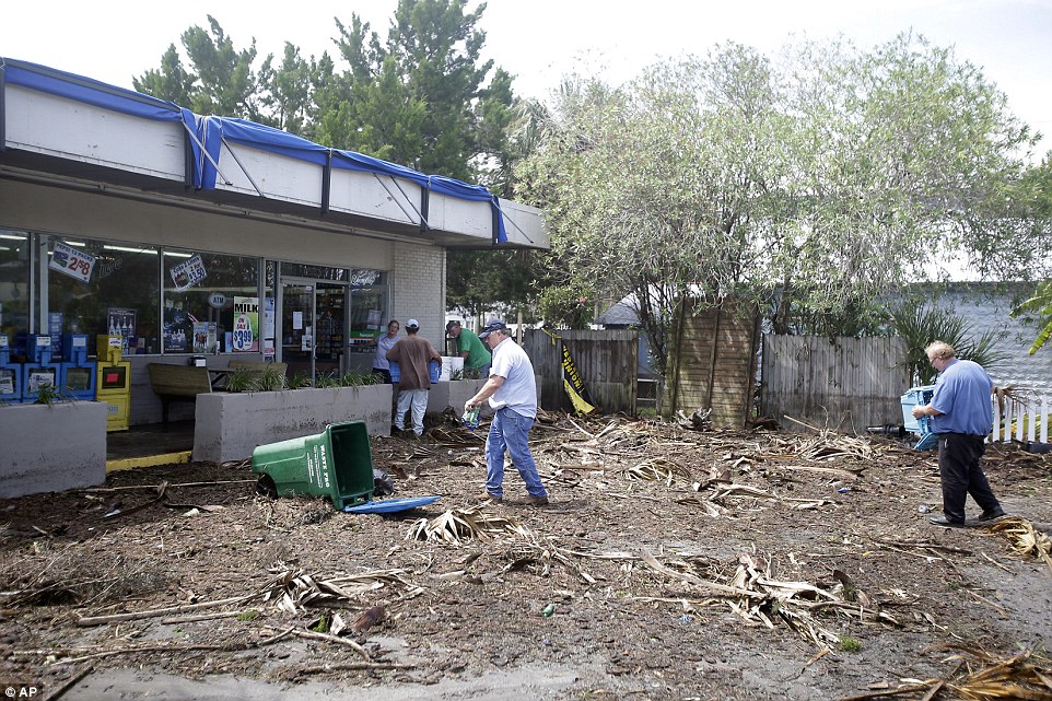  Workers clean up debris, caused by Hurricane Hermine, in the parking lot in front of convenience store in Cedar Key, Florida 