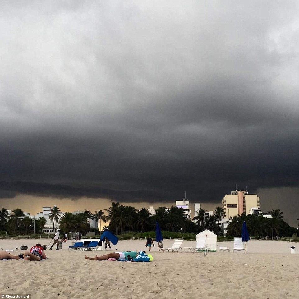 Dark storms gather overhead at the beach in Miami, Florida where the storm is expected to hit overnight 