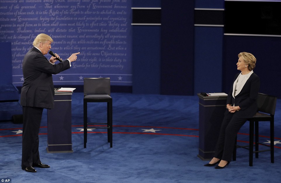 Donald Trump stands and points his finger at Hillary Clinton as he speaks during the second presidential debate on Sunday