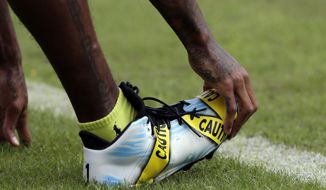 Washington Redskins wide receiver DeSean Jackson (11) wears cleats with a police caution tape theme during warm ups before an NFL football game against the Cleveland Browns Sunday, Oct. 2, 2016, in Landover, Md. (AP Photo/Chuck Burton)