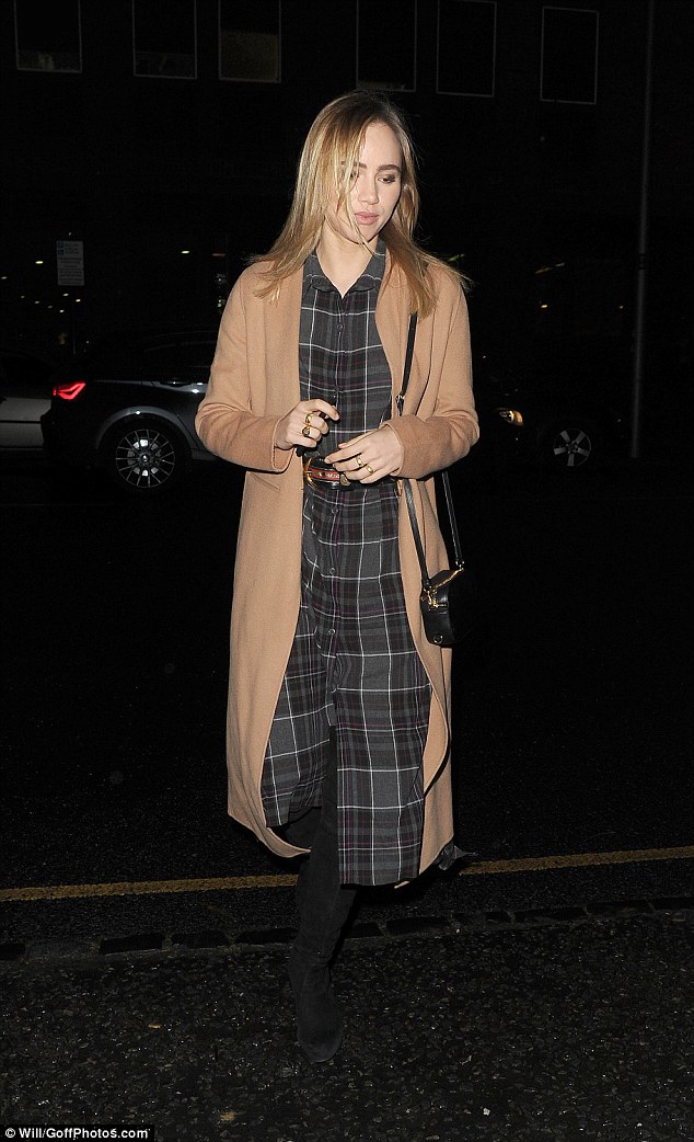 Stylish Suki: The Burberry and Marks and Spencer model wrapped up in a long, thick camel coat. Underneath she wore a tartan print dress which covered her slender frame right down to her black boots