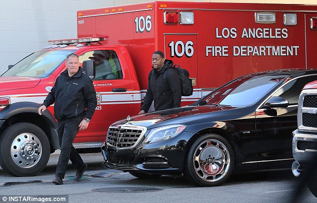 The star's car: This is the black Maybach he was driven out of the hospital with. The two men are his security guards