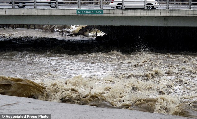 Traffic crosses the raging Truckee River where it runs near the Grand Sierra hotel-casino. The area remains under a flood warning until Tuesday